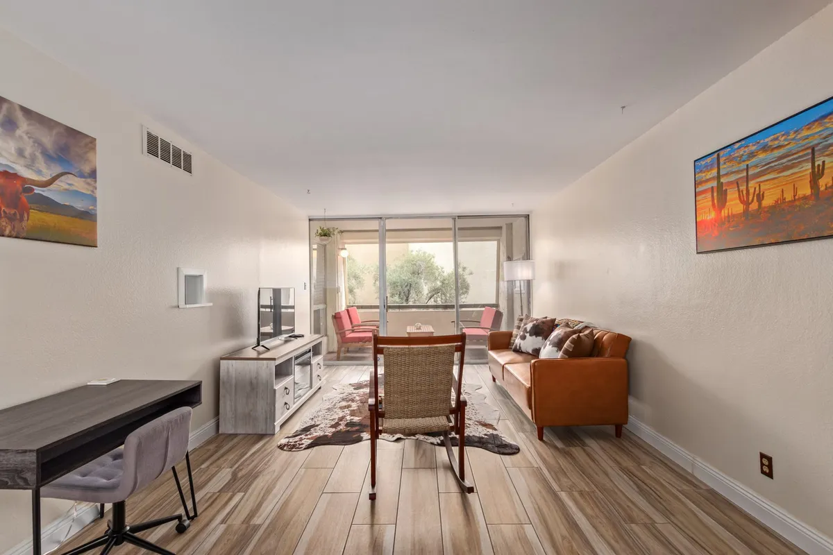 This interior shot showcases a living area with a sofa, dining table, television, and artwork on the wall. The setup supports multiple activities—relaxing, entertaining, working, or enjoying meals—with an ambiance that bridges privacy and community.