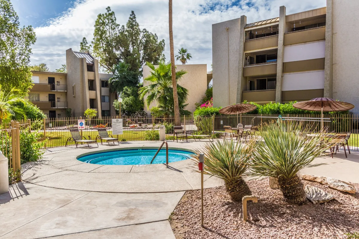 The image showcases another angle of the swimming pool, emphasizing the lush surrounding greenery, ample seating with umbrellas, and a welcoming environment perfect for both quiet afternoons and social gatherings.